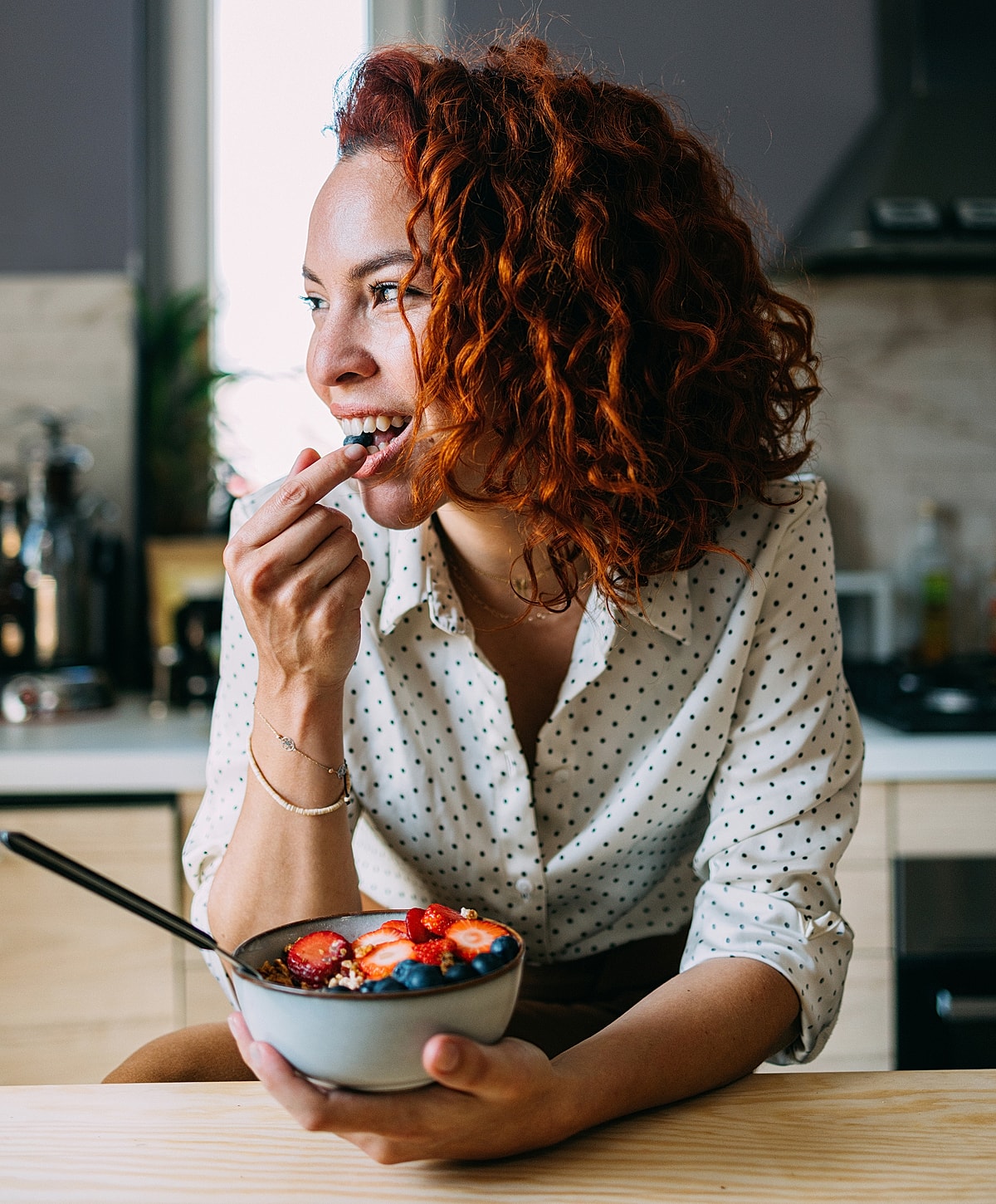Woman enjoying a healthy bowl of fruit.