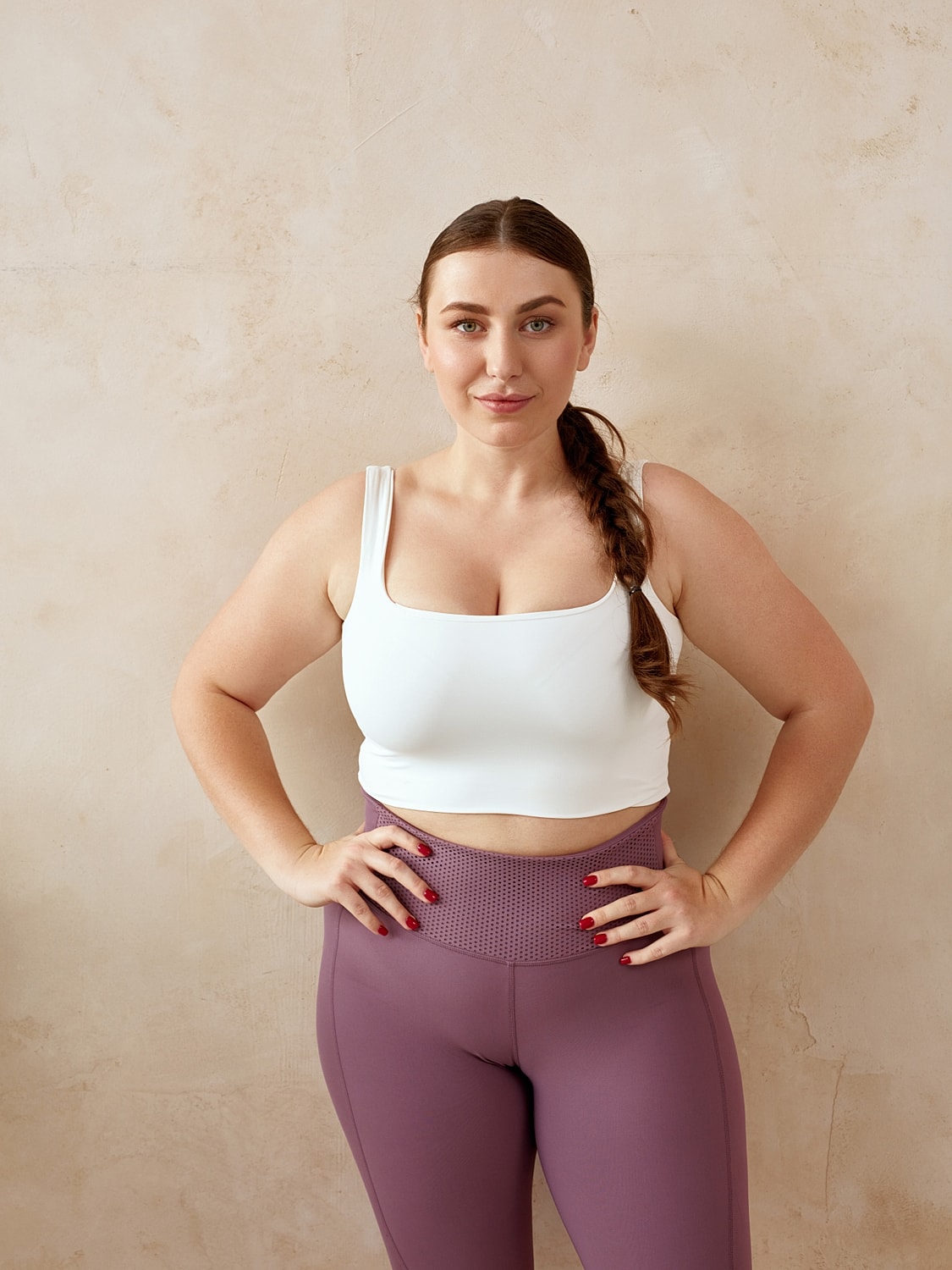 Woman in activewear posing against a neutral background.