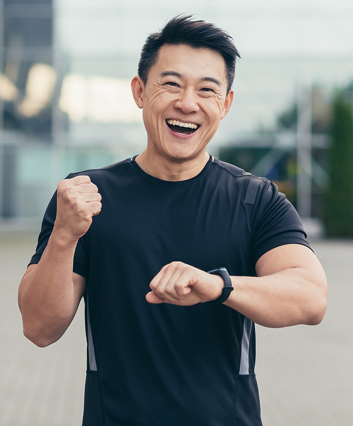Smiling man in athletic wear checking watch.