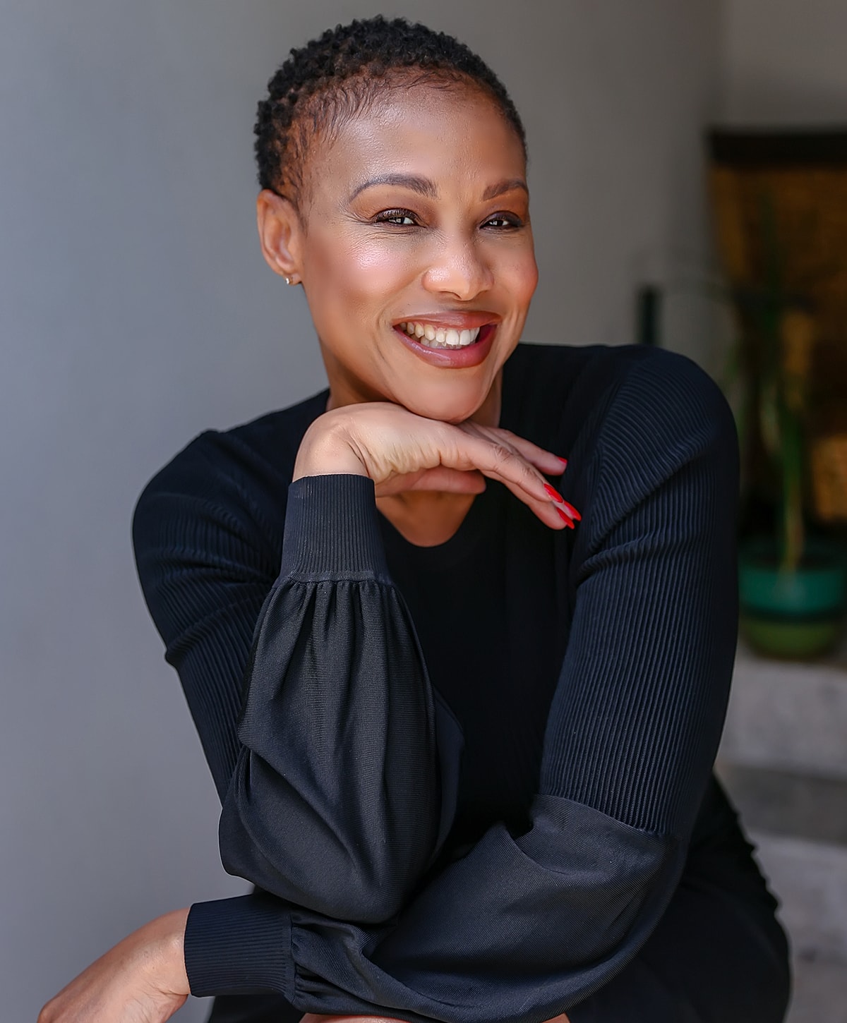 Smiling woman with short hair in black attire.
