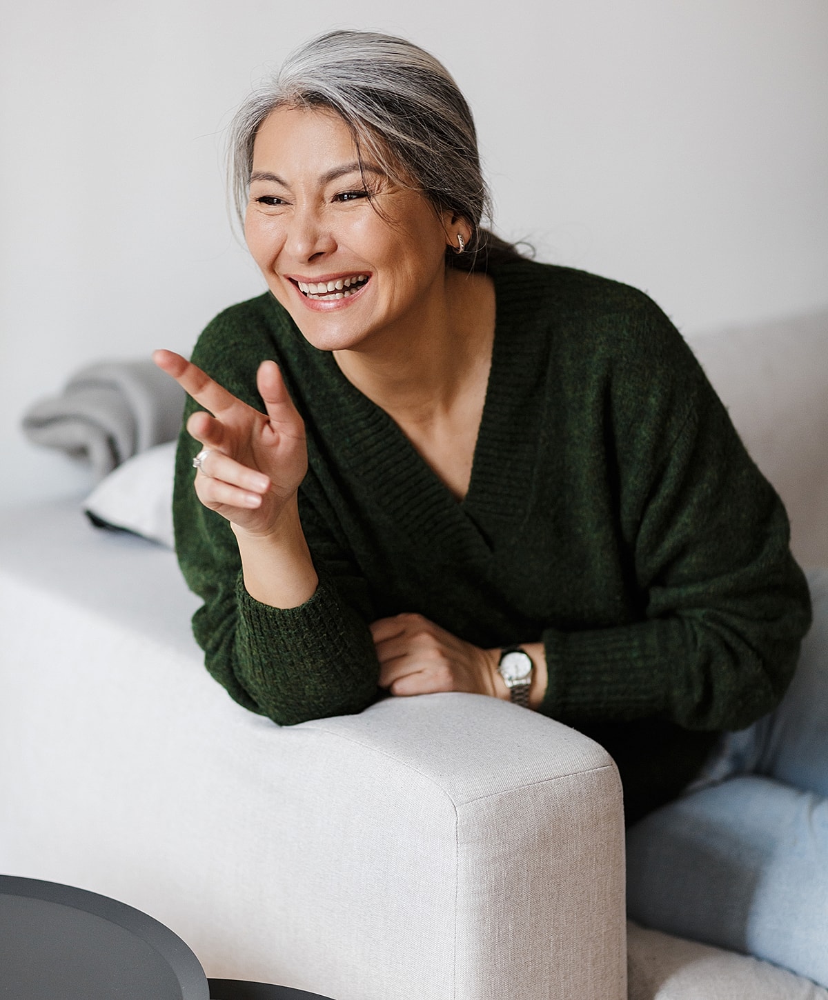 Smiling woman in a cozy green sweater.