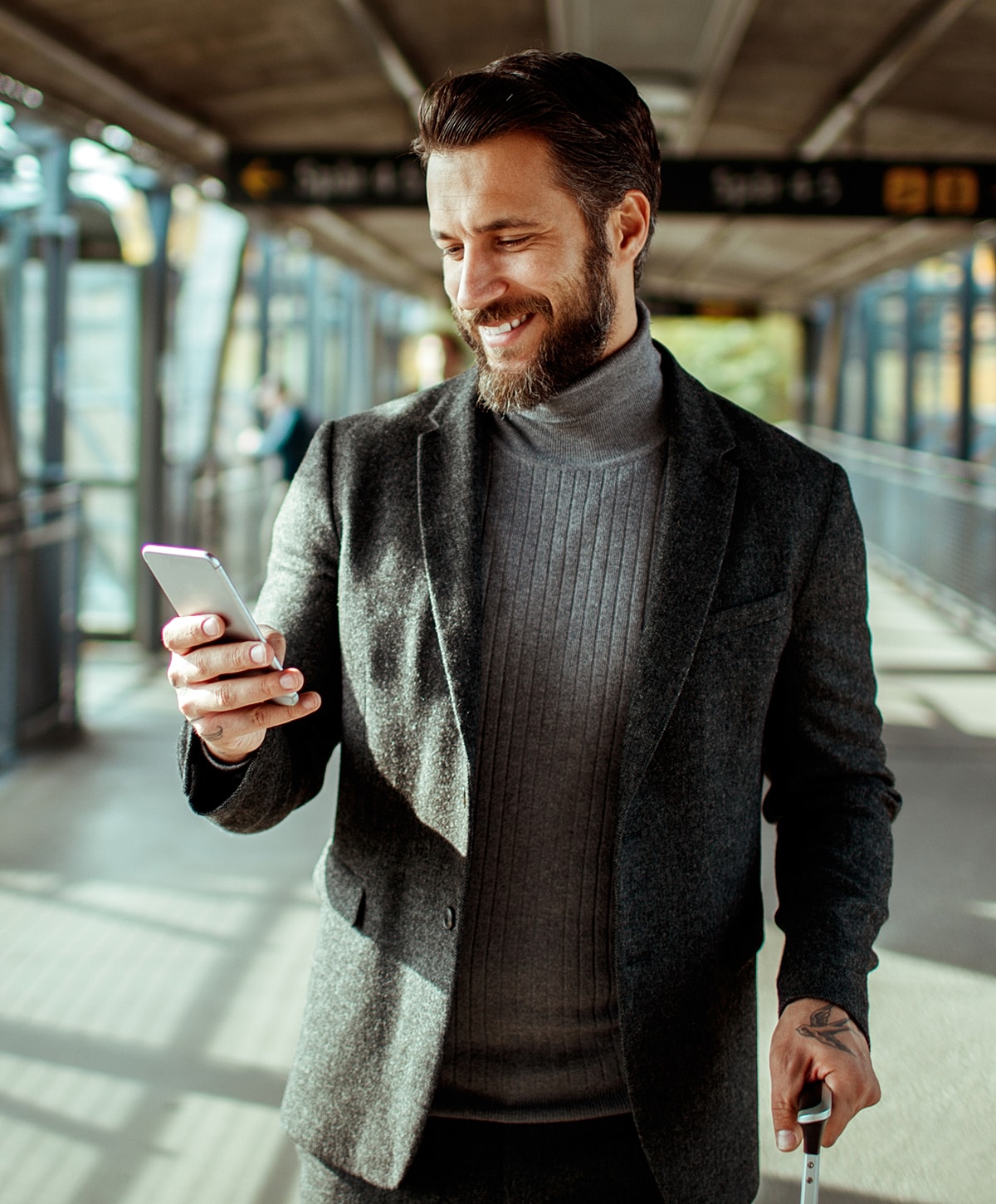 Smiling man in a stylish suit using smartphone.