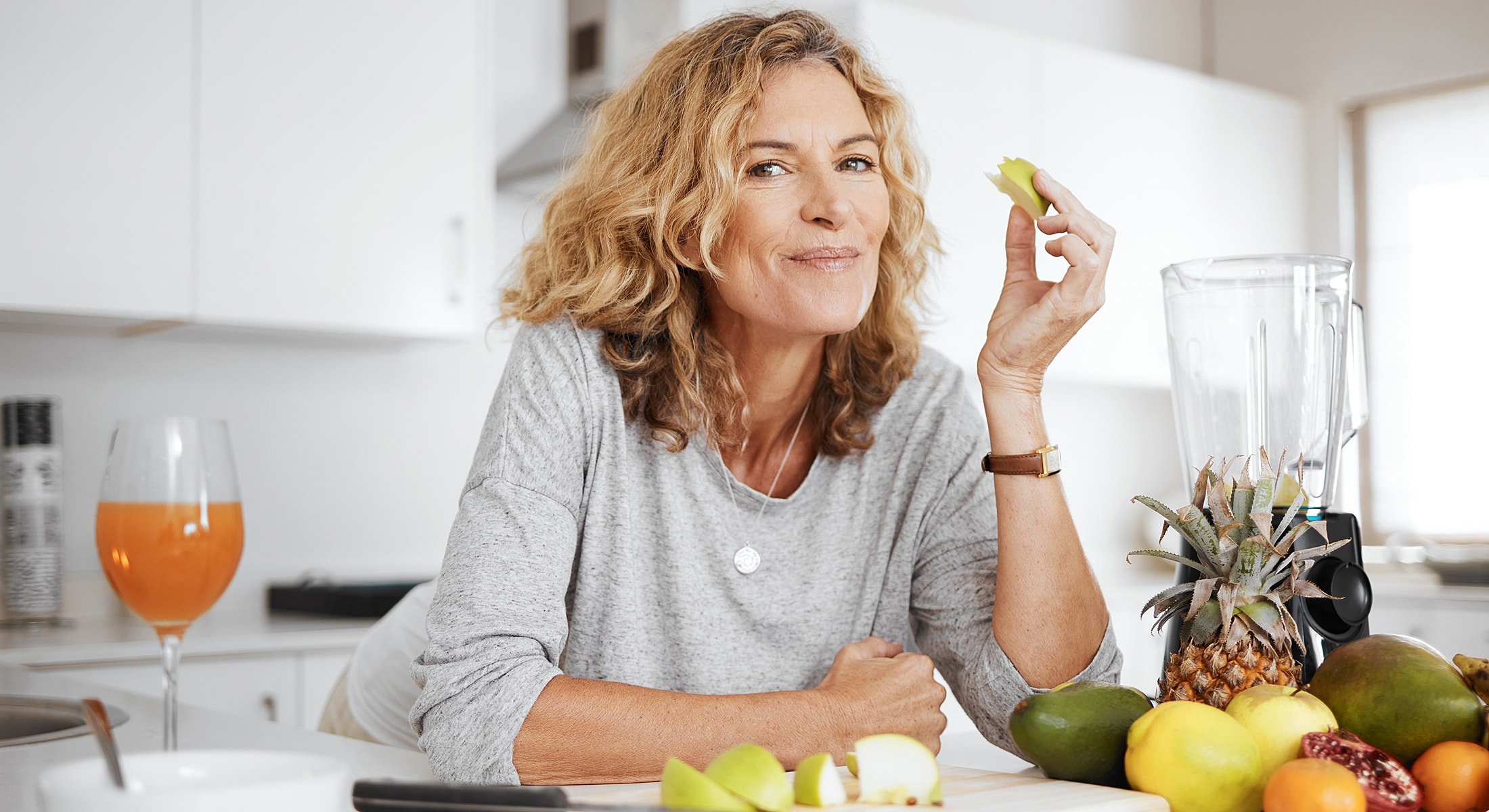 Woman enjoying healthy snacks in kitchen setting.