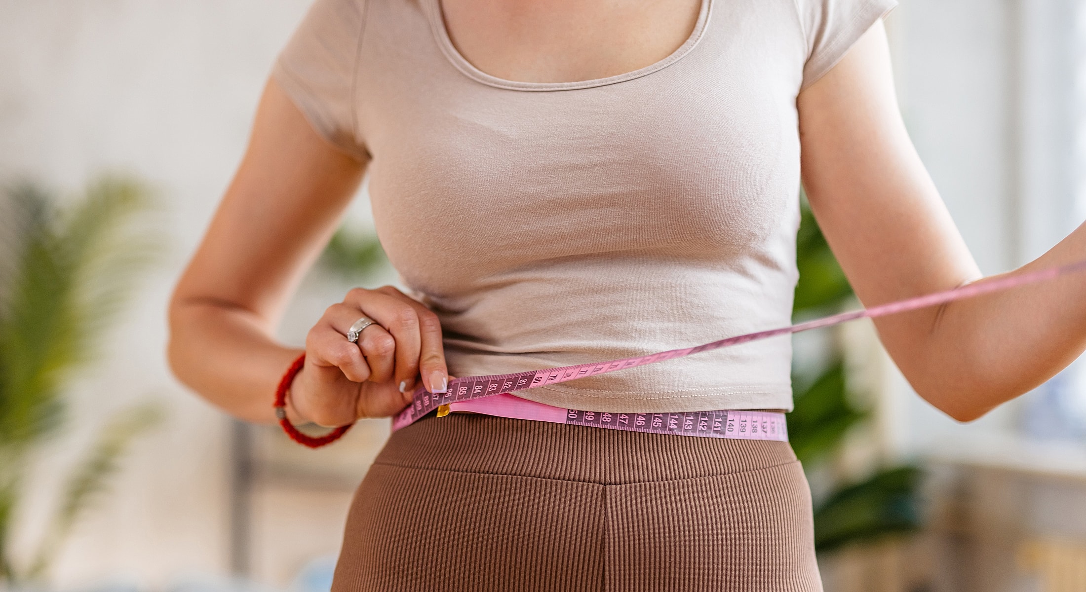 Measuring waist with a fabric tape measure.