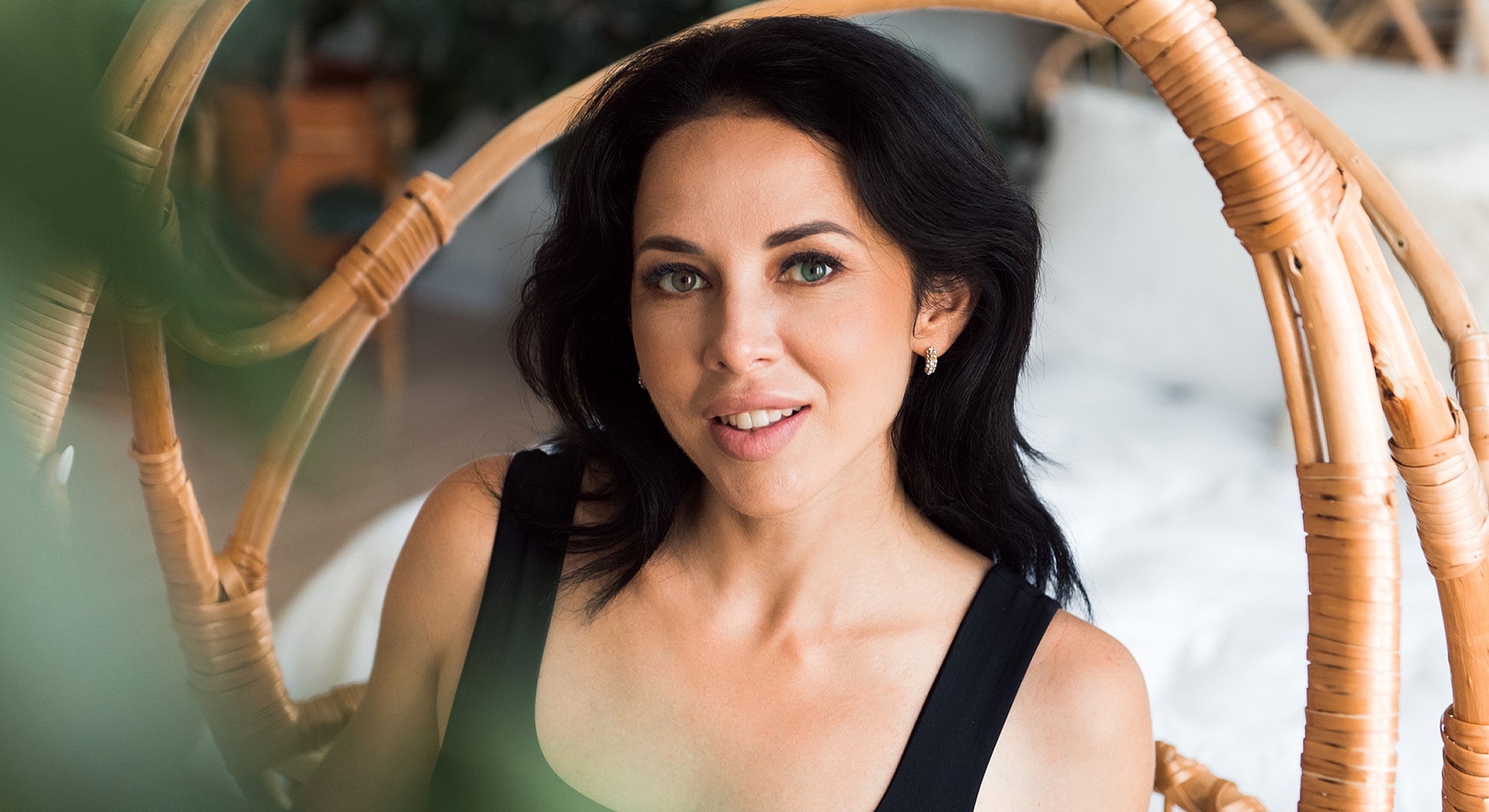 Woman smiling in a cozy, stylish setting.